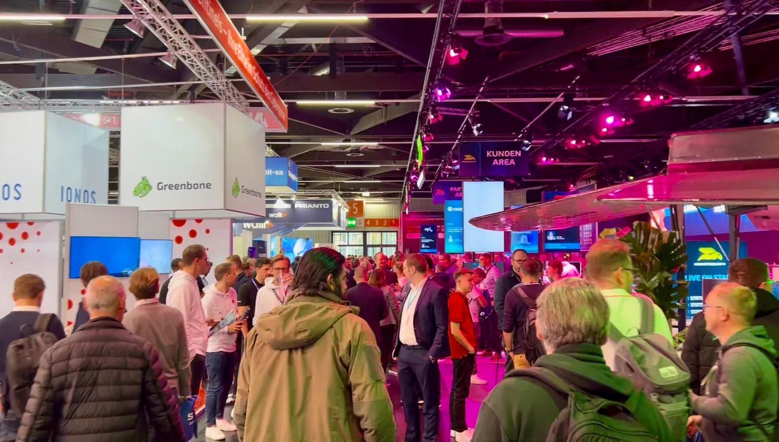 Crowded technology trade show it-sa in Nurnberg with colorful exhibition booths from european cybersecurity, infosec, and IT.